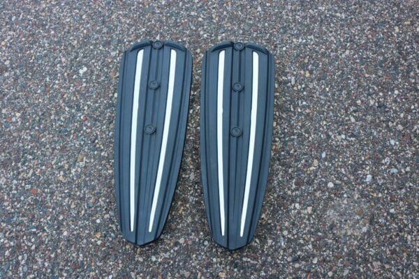 A pair of black and white plastic fins laying on the ground.