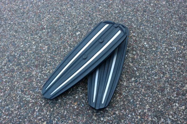 A pair of black and silver plastic shoes on the ground.
